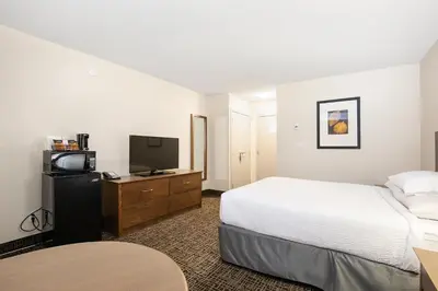 a hotel room with a bed and a flat screen tv at Ramada by Wyndham Kamloops in Kamloops