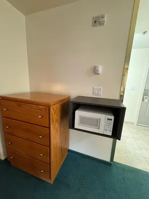 a kitchen with a microwave and a wooden cabinet at Western Budget Motel #1 & 2 Whitecourt in Whitecourt