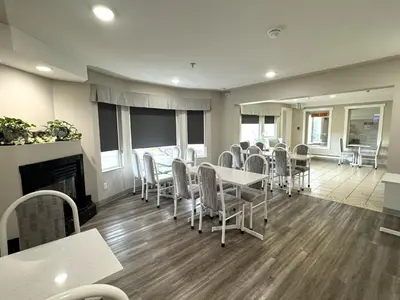 a dining room with a table and chairs and a fireplace at Western Budget Motel #1 & 2 Whitecourt in Whitecourt