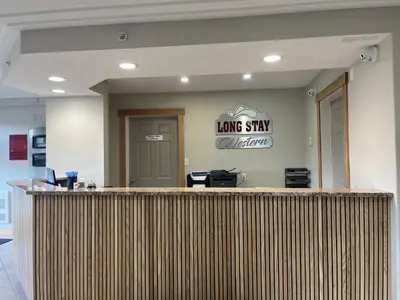 a lobby with a longstay sign on the wall at Western Budget Motel #1 & 2 Whitecourt in Whitecourt
