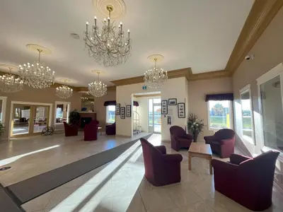 a lobby with chairs and chandeliers at Western Budget Motel Ponoka in Ponoka