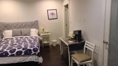 a small bedroom with a bed and a desk with a microwave at White Rose House in White Rock