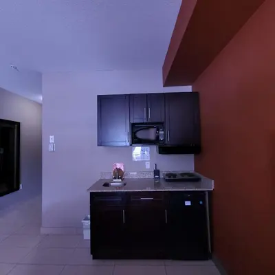 a kitchen with black cabinets and a counter top at Wabasca Inn in Wabasca