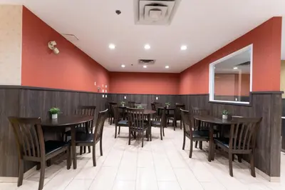 a dining room with wooden tables and chairs at Prestige Aberdeen Lodge Kamloops in Kamloops