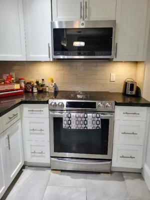a kitchen with a stove and a microwave at New Urban Modern Main Street House in Vancouver