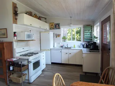 a kitchen with a white stove and a refrigerator at Malaspina Strait Cottage in Powell River