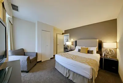 a hotel room with a bed and a chair at Coast Kamloops Hotel & Conference Centre in Kamloops