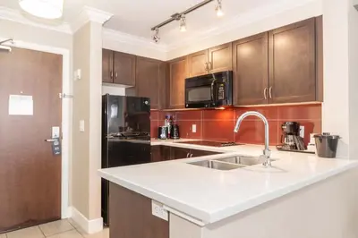 a kitchen with a sink and a counter top at Sandman Hotel and Suites Abbotsford in Abbotsford
