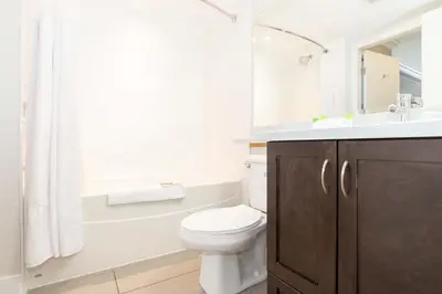 a bathroom with a toilet and a tub and a sink at Sandman Hotel and Suites Abbotsford in Abbotsford
