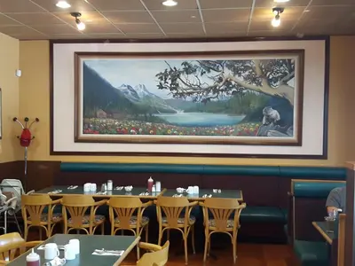a dining room with a large painting on the wall at Fuller Lake Chemainus Motel in Chemainus