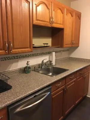 a kitchen with wooden cabinets and a sink at Twelve Oaks By Marquee Vancouver in Vancouver