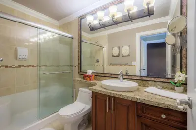 a bathroom with a toilet and a shower and a sink at Vancouver Yuelai Guesthouse in Coquitlam