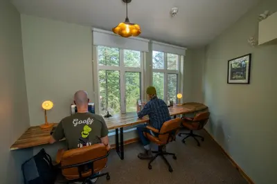 two men sitting at a table in a room at HI Banff Alpine Centre - Hostel in Banff