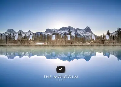 a poster for the malcolm hotel with mountains in the background at The Malcolm Hotel in Canmore