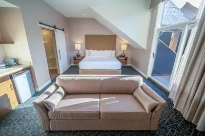 a hotel room with a bed and a couch at The Malcolm Hotel in Canmore
