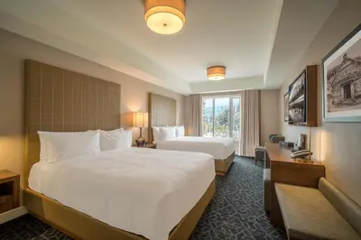a hotel room with two beds and a window at The Malcolm Hotel in Canmore