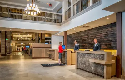 two people standing at a counter in a lobby at Delta Hotels by Marriott Grand Okanagan Resort in Kelowna