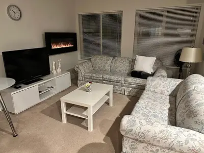 a living room with two couches and a tv at Albion Stay in Maple Ridge District Municipality