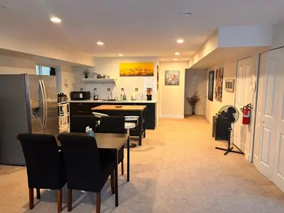 a kitchen with a table and chairs and a refrigerator at Albion Stay in Maple Ridge District Municipality
