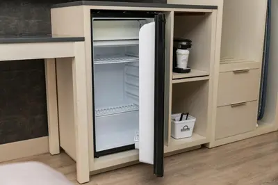 an empty refrigerator with its door open in a kitchen at Days Inn by Wyndham 100 Mile House in One Hundred Mile House