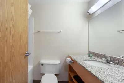 a bathroom with a toilet and a sink and a mirror at Best Western Grande Prairie in Grande Prairie