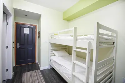 a bunk bed room with two bunk beds and a door at Alpenglow Lodge by Bill in Whistler