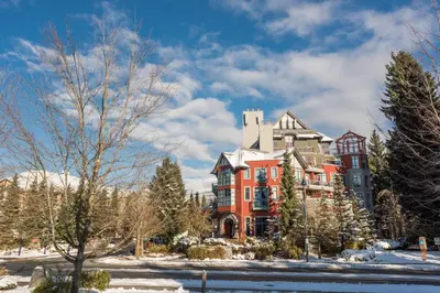 a large red building in the snow with trees at Alpenglow Lodge by Bill in Whistler
