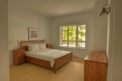a bedroom with a bed and a window at Waters Edge Shoreside Suites in Ucluelet