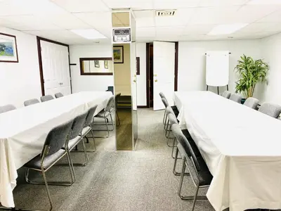 a conference room with white tables and chairs at Happy Day Inn in Burnaby