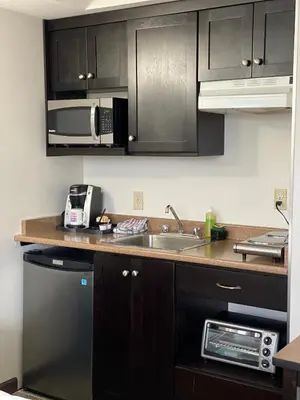a kitchen with a sink and a microwave at Happy Day Inn in Burnaby