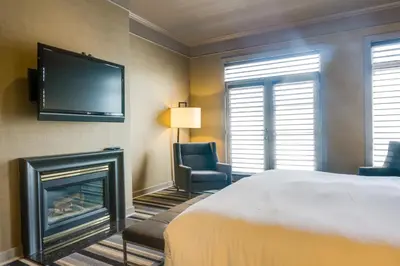 a hotel room with a bed and a fireplace at Hotel Arts Kensington in Calgary