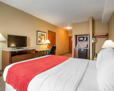 a hotel room with a large bed and a flat screen tv at Comfort Inn & Suites in Airdrie