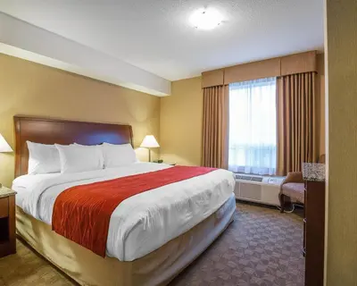 a hotel room with a large bed and a window at Comfort Inn & Suites in Airdrie
