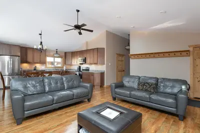 a living room with two leather couches and a kitchen at Mama Bear in Valemount