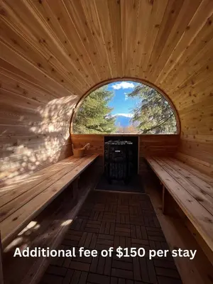 an interior of a wooden sauna with an oval window at Aspen in Valemount