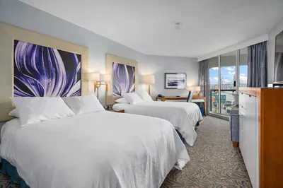 a hotel room with two beds and a balcony at Inn At The Quay in New Westminster