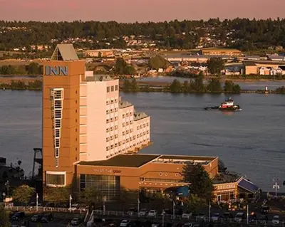 a large building with a boat in the water at Inn At The Quay in New Westminster