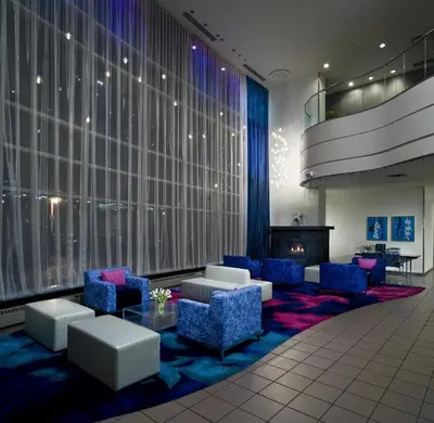 a lobby with blue chairs and a table and a fireplace at Inn At The Quay in New Westminster