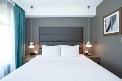 a bedroom with a large bed with two lights above it at Sandman Signature Calgary Airport Hotel in Calgary