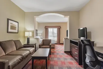a living room with a couch and a tv at Best Western Plus Red Deer Inn & Suite in Red Deer