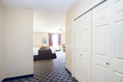 a bedroom with a bed and a closet with a door at West Country Inn in Drayton Valley