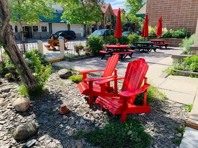 a group of red chairs and tables and umbrellas at Jasper Downtown Hostel in Jasper