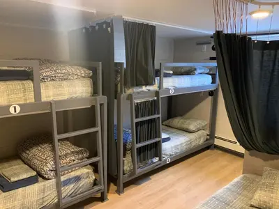 a room with three bunk beds and curtains at Jasper Downtown Hostel in Jasper