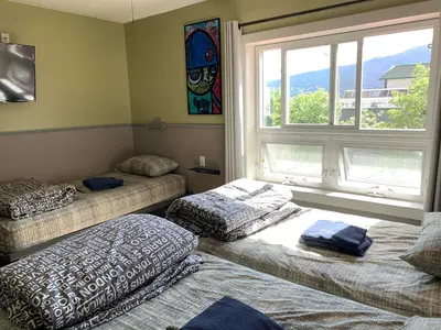 a room with two beds and a window at Jasper Downtown Hostel in Jasper