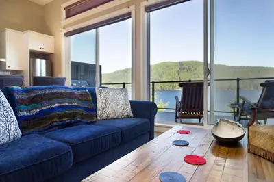 a living room with a blue couch and a table at Avatar by Eagle Reach Properties in Port Renfrew