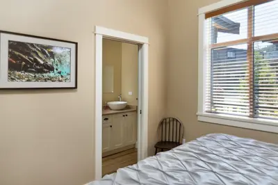 a bedroom with a bed and a sink and a window at Avatar by Eagle Reach Properties in Port Renfrew