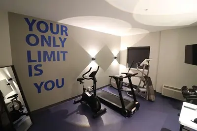 a gym with exercise bikes and a sign on the wall at Days Inn by Wyndham Stony Plain in Stony Plain