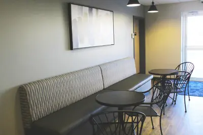 a waiting room with two tables and chairs at Days Inn by Wyndham Stony Plain in Stony Plain