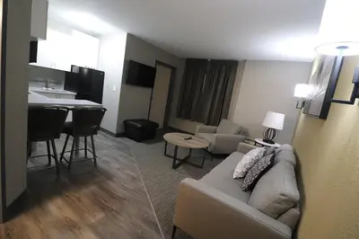 a living room with a couch and a kitchen at Days Inn by Wyndham Stony Plain in Stony Plain