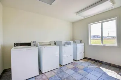 a laundry room with white appliances and a window at Motel 6-Grande Prairie, AB in Grande Prairie